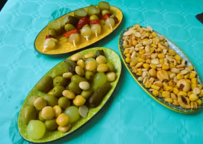 Aperitivos con aceitunas, encurtidos y frutos secos servidos en bandejas en Café Plaza Palencia