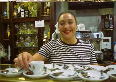 Camarera sirviendo café detrás de la barra