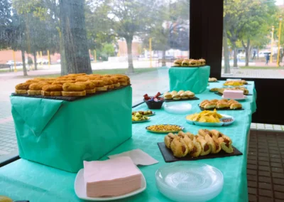 Mesa preparada con bandejas de pinchos, bocadillos y aperitivos para evento en la terraza cerrada de Café Plaza Palencia