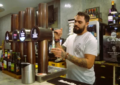 Camarero sirviendo cerveza de bodega Estrella Galicia desde los tiradores en la barra del Café Plaza Palencia