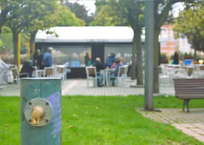 Clientes en terraza de Café Plaza desde vista lateral del parque